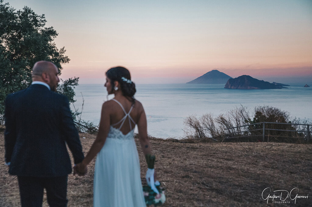 Fotografo matrimonio Lipari: sposi con Panarea e Stromboli sullo sfondo.